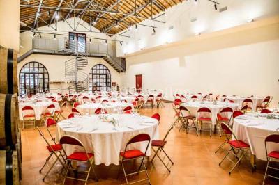 Une voiture bleue traverse un chemin bordé de vignes et de murets en pierre sous un ciel dégagé.