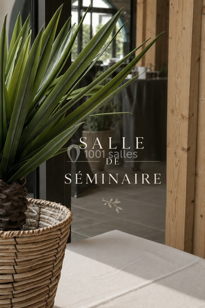 Plante en pot devant une baie vitrée avec l'inscription ’Salle de séminaire’ visible sur la vitre.