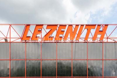 Façade vitrée avec le nom ’Le Zénith’ écrit en grandes lettres rouges sur une structure métallique.