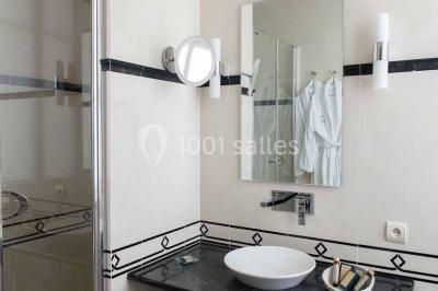 Assiette gastronomique avec légumes colorés, asperges, sauce crémeuse, tranche de viande et fleur comestible en décoration.