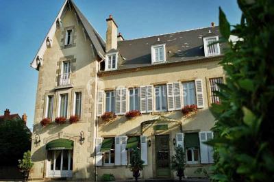 Assiette gastronomique avec légumes colorés, asperges, sauce crémeuse, tranche de viande et fleur comestible en décoration.