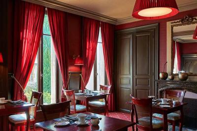 Assiette gastronomique avec légumes colorés, asperges, sauce crémeuse, tranche de viande et fleur comestible en décoration.