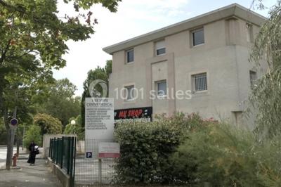 Bâtiment beige à trois étages entouré de végétation, avec un panneau indiquant un centre médical à l'entrée.