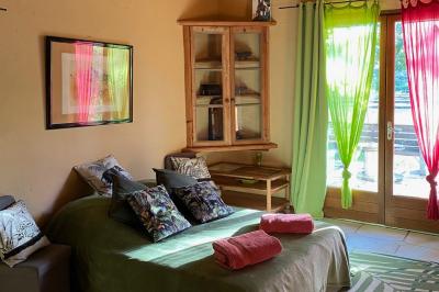 Structure en bois triangulaire devant des bancs disposés en plein air sur une pelouse entourée d'arbres.