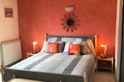 Structure en bois triangulaire devant des bancs disposés en plein air sur une pelouse entourée d'arbres.