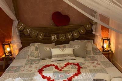 Structure en bois triangulaire devant des bancs disposés en plein air sur une pelouse entourée d'arbres.