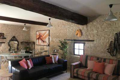 Structure en bois triangulaire devant des bancs disposés en plein air sur une pelouse entourée d'arbres.