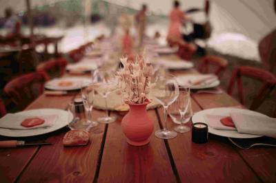 Des personnes dansent en couple sur une piste éclairée par des lumières colorées, tandis que d'autres sont assises autour.