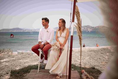 Des personnes dansent en couple sur une piste éclairée par des lumières colorées, tandis que d'autres sont assises autour.