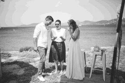 Des personnes dansent en couple sur une piste éclairée par des lumières colorées, tandis que d'autres sont assises autour.