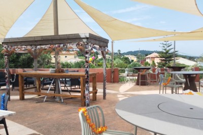 Des personnes dansent en couple sur une piste éclairée par des lumières colorées, tandis que d'autres sont assises autour.