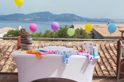 Des personnes dansent en couple sur une piste éclairée par des lumières colorées, tandis que d'autres sont assises autour.