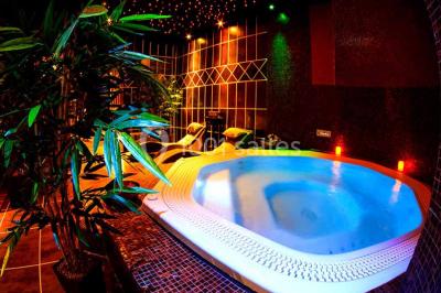 Des personnes dansent en couple sur une piste éclairée par des lumières colorées, tandis que d'autres sont assises autour.