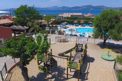 Des personnes dansent en couple sur une piste éclairée par des lumières colorées, tandis que d'autres sont assises autour.