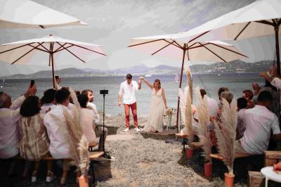 Des personnes dansent en couple sur une piste éclairée par des lumières colorées, tandis que d'autres sont assises autour.