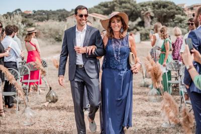 Des personnes dansent en couple sur une piste éclairée par des lumières colorées, tandis que d'autres sont assises autour.