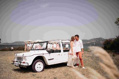 Des personnes dansent en couple sur une piste éclairée par des lumières colorées, tandis que d'autres sont assises autour.