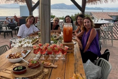 Des personnes dansent en couple sur une piste éclairée par des lumières colorées, tandis que d'autres sont assises autour.