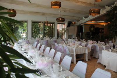 Des personnes dansent en couple sur une piste éclairée par des lumières colorées, tandis que d'autres sont assises autour.