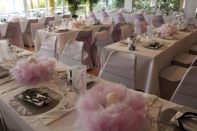 Des personnes dansent en couple sur une piste éclairée par des lumières colorées, tandis que d'autres sont assises autour.