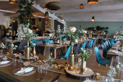 Des personnes dansent en couple sur une piste éclairée par des lumières colorées, tandis que d'autres sont assises autour.