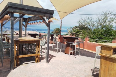 Des personnes dansent en couple sur une piste éclairée par des lumières colorées, tandis que d'autres sont assises autour.