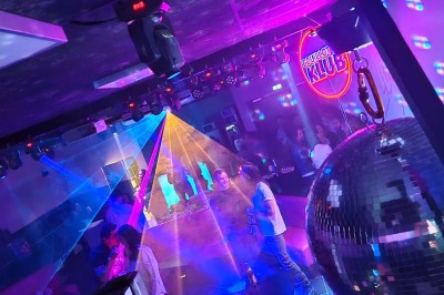 Un plongeur observe deux poissons nageant près d'un fond marin couvert d'algues et de végétation aquatique.