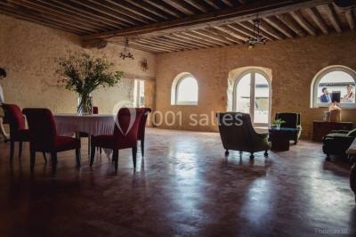 Voitures garées en file sur un terrain herbeux entouré d'arbres par une journée ensoleillée.