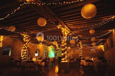 Voitures garées en file sur un terrain herbeux entouré d'arbres par une journée ensoleillée.