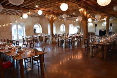 Voitures garées en file sur un terrain herbeux entouré d'arbres par une journée ensoleillée.