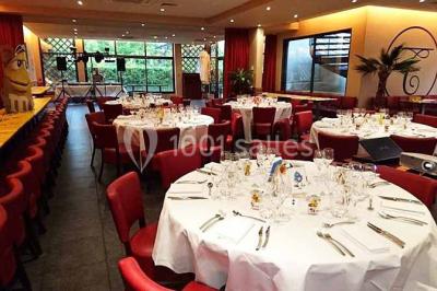 Moto miniature sculptée en chocolat, posée sur un socle rond, dans un environnement de cuisine professionnelle.