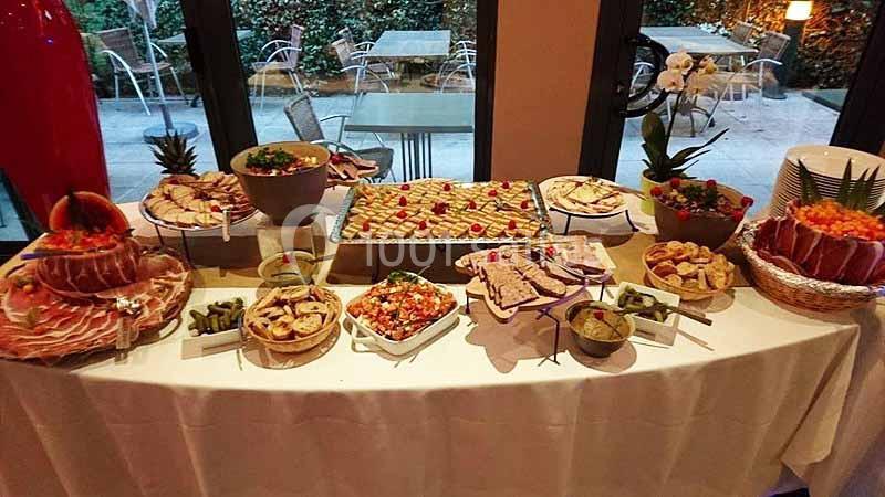 Buffet varié avec charcuterie, fruits, légumes, pains et plats préparés, disposés sur une table blanche.