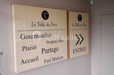 Moto miniature sculptée en chocolat, posée sur un socle rond, dans un environnement de cuisine professionnelle.