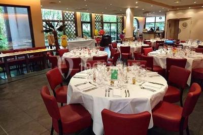 Moto miniature sculptée en chocolat, posée sur un socle rond, dans un environnement de cuisine professionnelle.