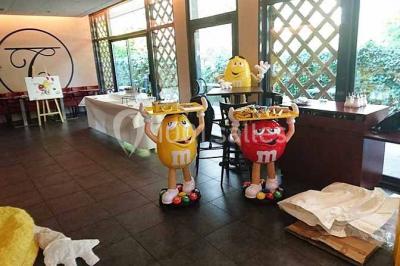 Moto miniature sculptée en chocolat, posée sur un socle rond, dans un environnement de cuisine professionnelle.