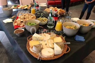 Moto miniature sculptée en chocolat, posée sur un socle rond, dans un environnement de cuisine professionnelle.