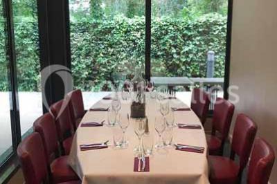 Moto miniature sculptée en chocolat, posée sur un socle rond, dans un environnement de cuisine professionnelle.