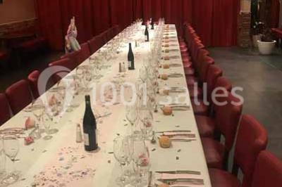 Moto miniature sculptée en chocolat, posée sur un socle rond, dans un environnement de cuisine professionnelle.