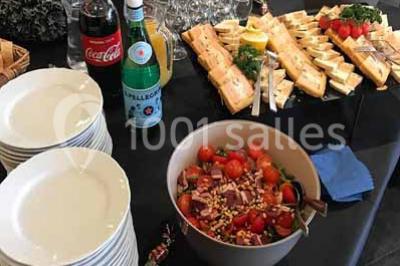 Moto miniature sculptée en chocolat, posée sur un socle rond, dans un environnement de cuisine professionnelle.