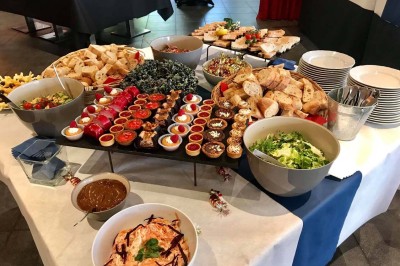 Terrasse de restaurant avec tables en bois, nappes rouges, couverts et verres, entourée de chaises en osier.