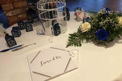 Terrasse de restaurant avec tables en bois, nappes rouges, couverts et verres, entourée de chaises en osier.