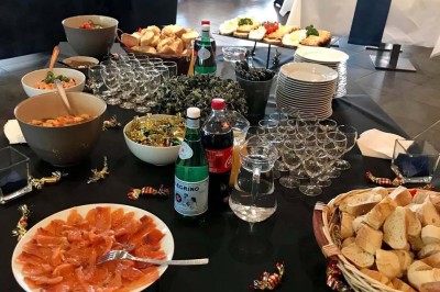 Terrasse de restaurant avec tables en bois, nappes rouges, couverts et verres, entourée de chaises en osier.