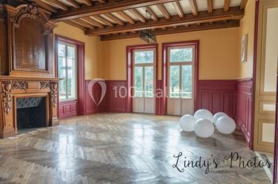 Vue d'un couloir lumineux menant à une chambre avec un lit, des murs clairs et un tapis au sol.