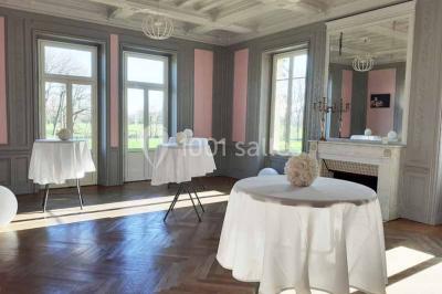 Vue d'un couloir lumineux menant à une chambre avec un lit, des murs clairs et un tapis au sol.