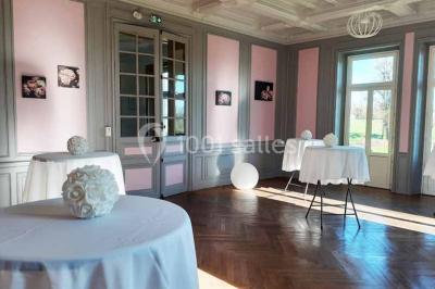 Vue d'un couloir lumineux menant à une chambre avec un lit, des murs clairs et un tapis au sol.