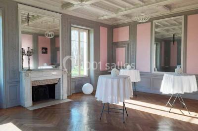 Vue d'un couloir lumineux menant à une chambre avec un lit, des murs clairs et un tapis au sol.
