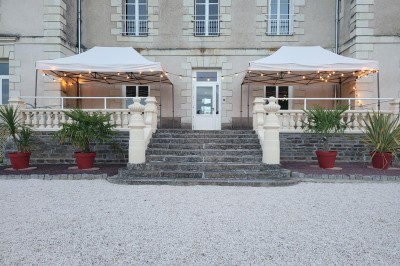 Vue d'un couloir donnant sur deux chambres lumineuses avec lits simples et parquet au sol.