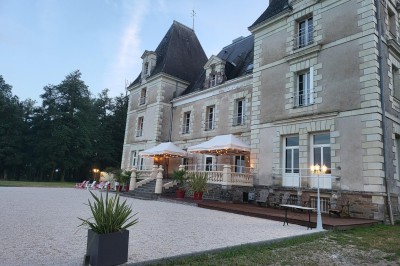 Vue d'un couloir donnant sur deux chambres lumineuses avec lits simples et parquet au sol.