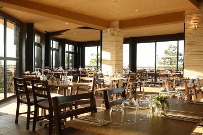 Salle de bain moderne avec meuble en bois clair, lavabo, miroir et douche vitrée équipée d'une pomme de douche.