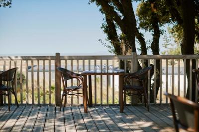 Salle de bain moderne avec meuble en bois clair, lavabo, miroir et douche vitrée équipée d'une pomme de douche.
